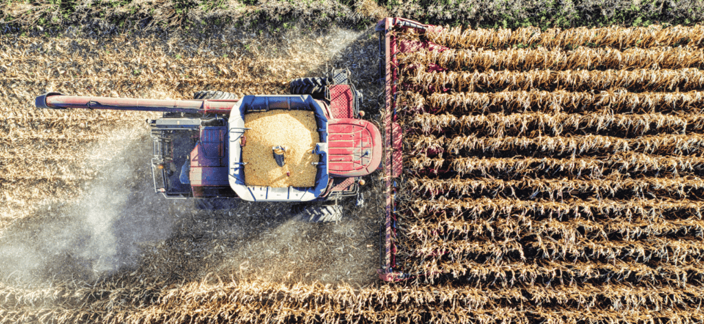 Overhead image of a a tractor reaping a field of wheat.