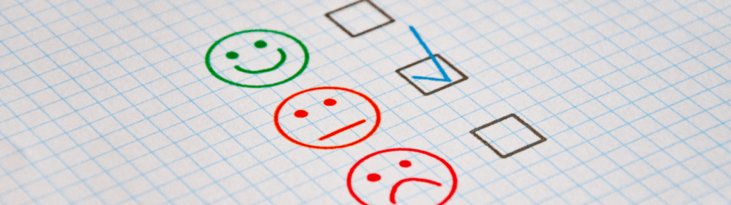 3 smiley faces drawn on a sheet of paper.